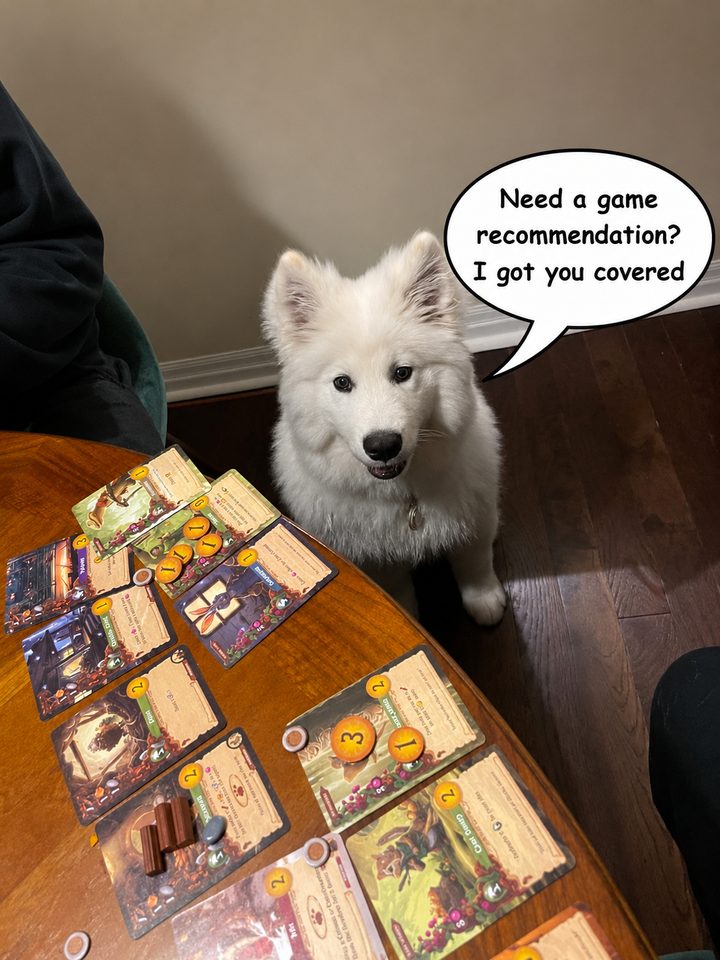 A fluffy white Samoyed puppy sitting beside a table of board game cards, with a speech bubble saying: Need a game recommendation? I got you covered.